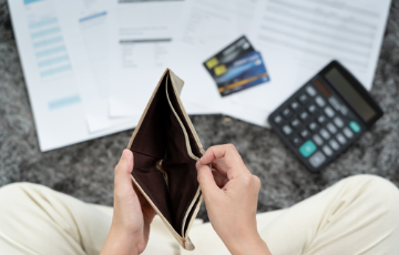 A woman holding an empty wallet